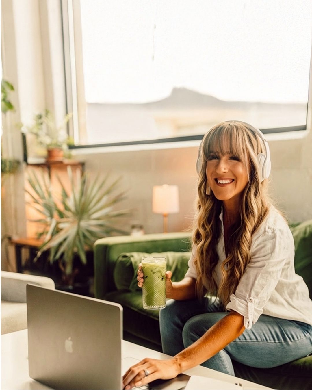 Sammy in her office listening to a podcast on a computer with headphones on
